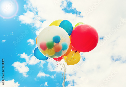 Bright colorful balloons over blue sky background