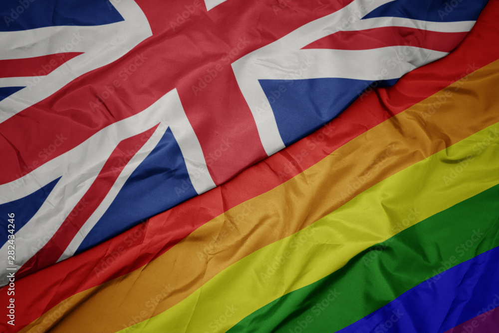 waving colorful gay rainbow flag and national flag of great britain. waving colorful gay rainbow flag and national flag of great britain.