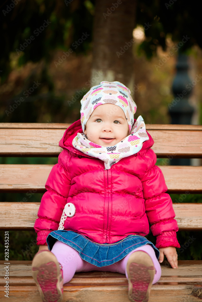 Happy little girl playing in a beautiful autumn park