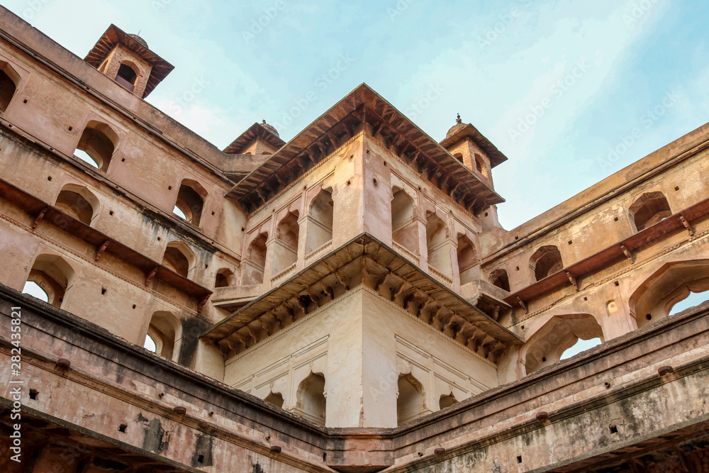 Facade, open windows and decorated dome roofs of the Orchha Palace in the sunset, Orchha, India