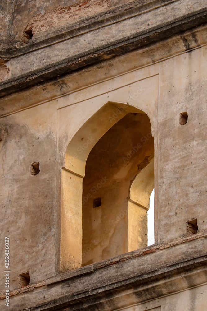 The evening sun shines at sunset through a window of the Orchha Palace, Orchha, India The evening sun shines at sunset through a window of the Orchha Palace, Orchha, India