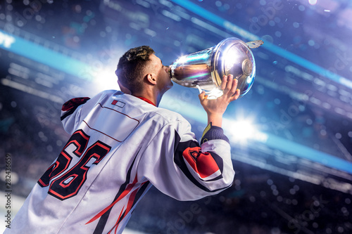 Hockey player celebrate goal. Hold cup in hand photo