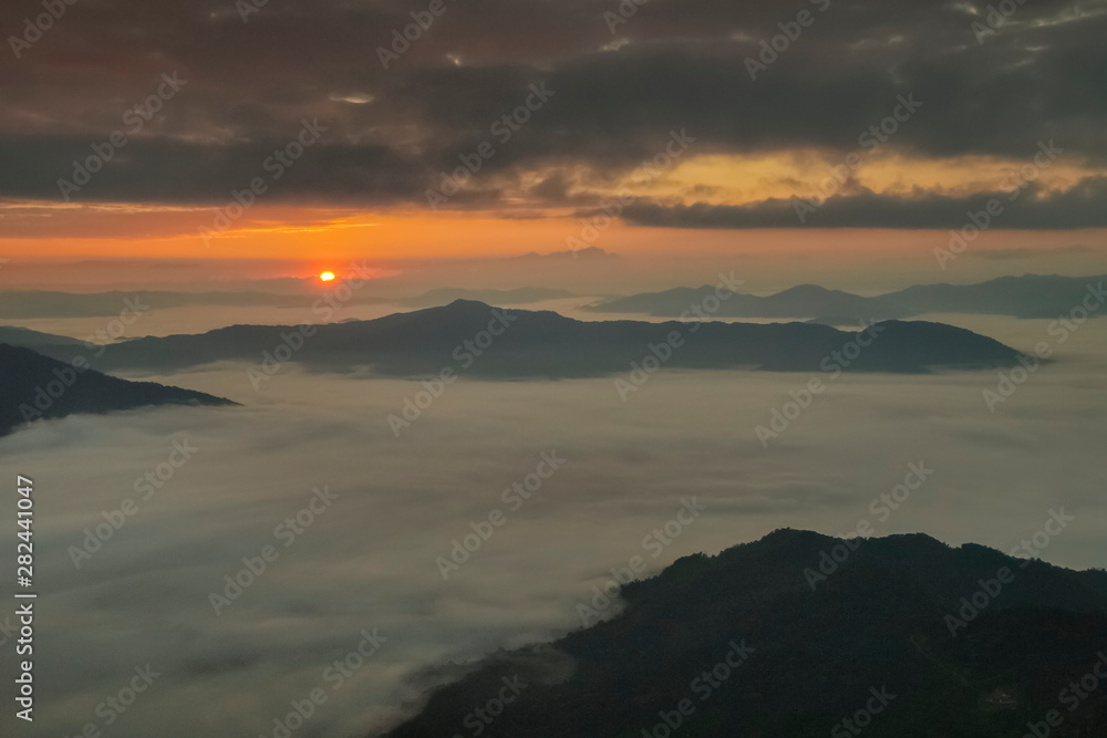 Mountain view morning of top hill around with sea of mist in valley with orange sun light and cloudy sky background, sunrise at Pha Tang, Chiang Rai, northern of Thailand. Mountain view morning of top hill around with sea of mist in valley with orange sun light and cloudy sky background, sunrise at Pha Tang, Chiang Rai, northern of Thailand.