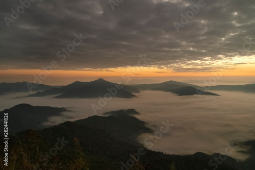 Mountain view morning of top hill around with sea of mist in valley with orange sun light and cloudy sky background, sunrise at Pha Tang, Chiang Rai, northern of Thailand.