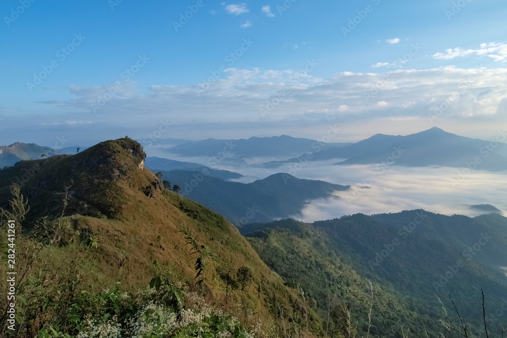 Mountain view morning of Peak mountain around with soft mist, sea of fog with blue sky background, sunrise at Pha Tang, Chiang Rai, northern of Thailand. Mountain view morning of Peak mountain around with soft mist, sea of fog with blue sky background, sunrise at Pha Tang, Chiang Rai, northern of Thailand.