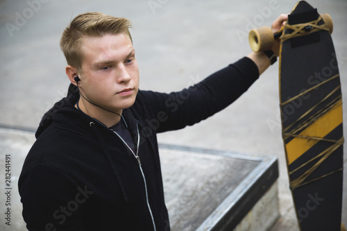 Fotografia, Obraz Motivated handicapped  guy with a longboard in the skatepark