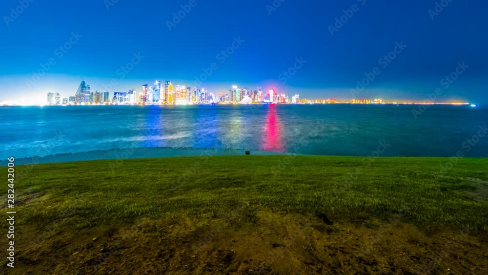 TIME LAPSE: The Capital city of Qatar by night reflections over Doha Bay from West Mound-Skyline viewpoint. Doha, Persian Gulf, Middle East, Arabian Peninsula. Night urban scenary. TIME LAPSE: The Capital city of Qatar by night reflections over Doha Bay from West Mound-Skyline viewpoint. Doha, Persian Gulf, Middle East, Arabian Peninsula. Night urban scenary.