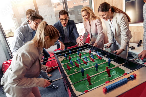 Coworkers playing table football photo