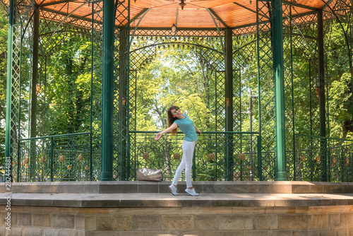 Young woman posing in the beautiful green garden pavilion. Mestsky or City park of Kosice, Slovakia (Slovensko). People, travel and summer holidays concept photo