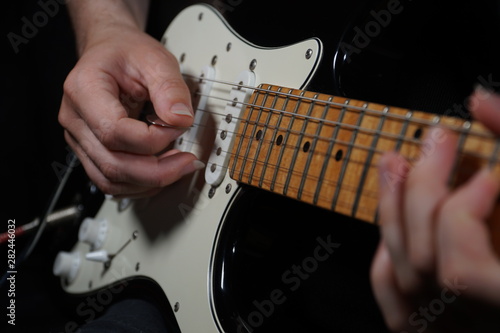 Guitar player on black background photo