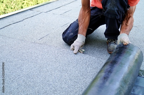 Obraz na płótnie worker installing tar foil on the rooftop of building