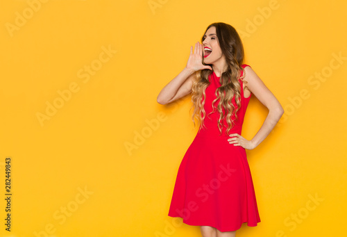 Happy Young Woman Is Holding Hand On Chin, Looking Away And Shouting