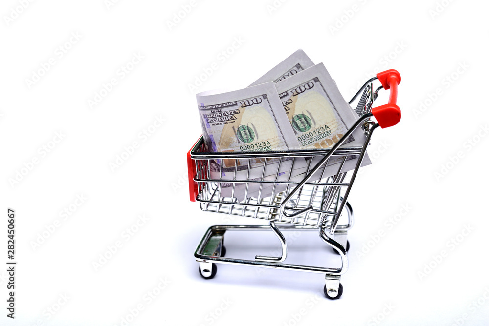 Shopping cart with one hundred US dollar bills isolated on white background.