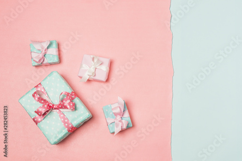 Gifts decorated with ribbons arranged on dual color surface © Freepik