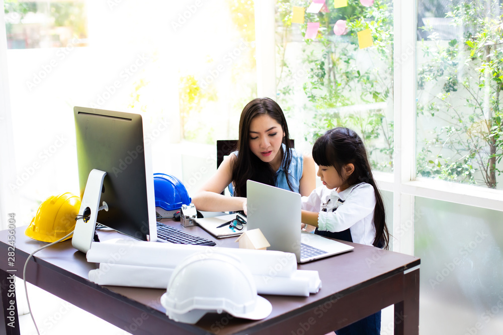 Businesswoman mother woman with daughter working at the computer. Mother working at home concept Businesswoman mother woman with daughter working at the computer. Mother working at home concept