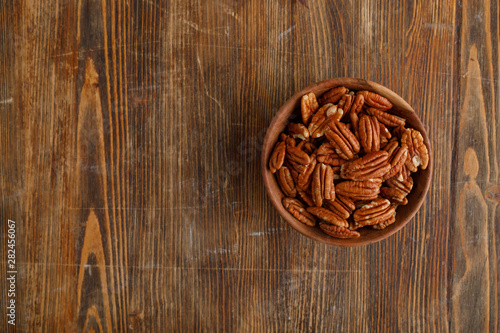 Wooden bowl of pecan nuts. Healthy eating concept