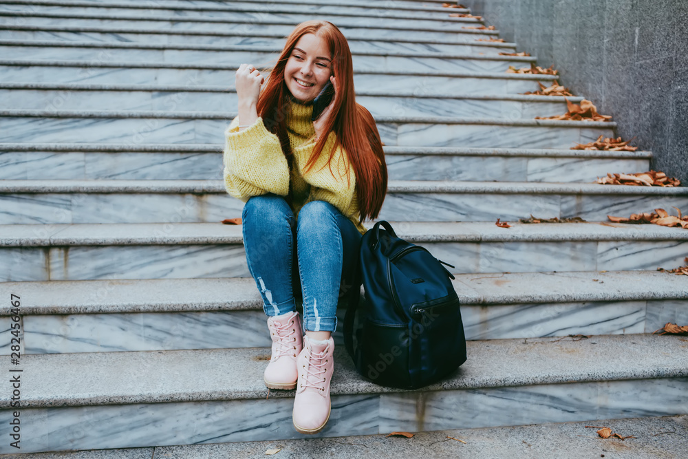 Pleased red hair woman in autumn clothes making selfie on smartphone outdoors Pleased red hair woman in autumn clothes making selfie on smartphone outdoors