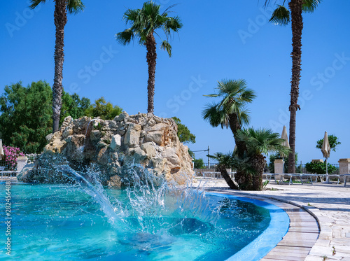 Pretty athletic sun tanned girl diving in a swimming pool on vacation