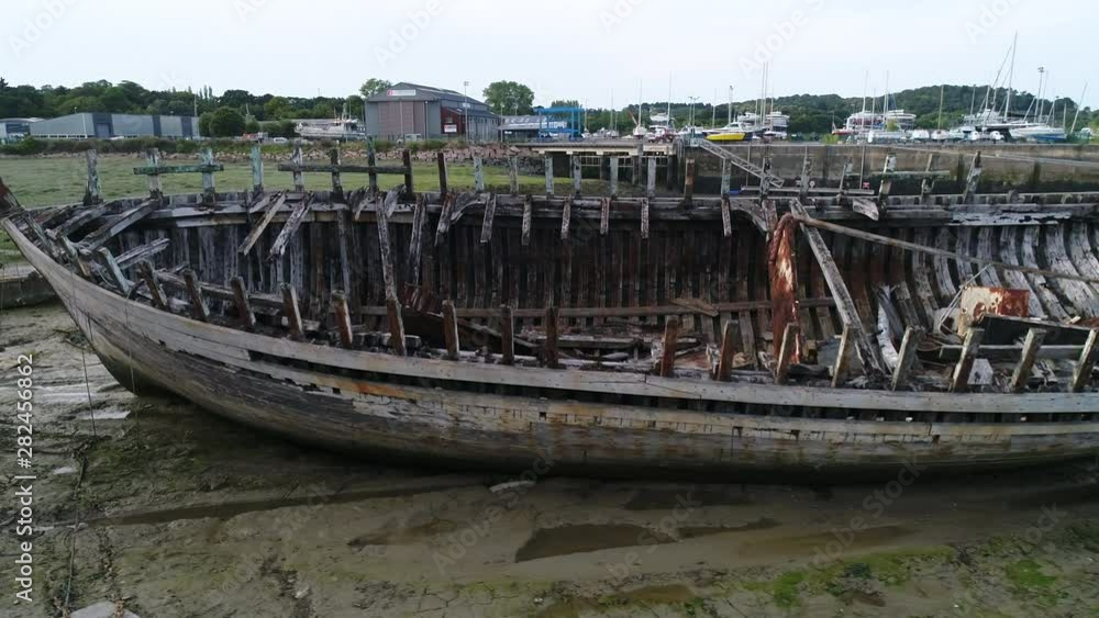 Aerial view. Skeleton of an old abandoned wooden boat. Cemetery of dead ships. The camera moves around the sides of the ship. Closeup dolly shot with drone. Aerial view. Skeleton of an old abandoned wooden boat. Cemetery of dead ships. The camera moves around the sides of the ship. Closeup dolly shot with drone.