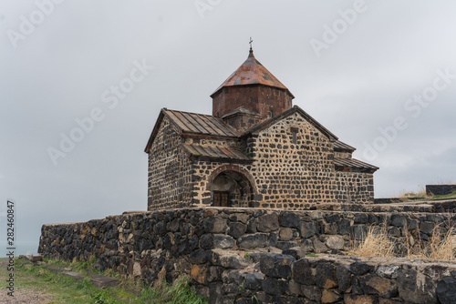 Ancient monastery  with weathered, cracked walls on the rocky shore of the cold sea