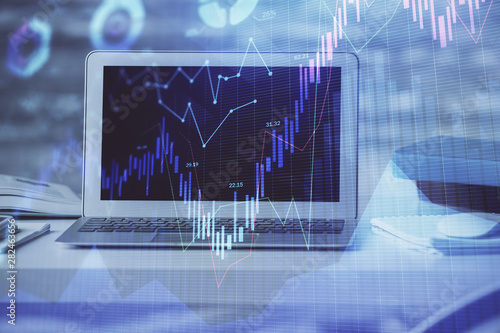 Financial chart drawing and table with computer on background. Double exposure. Concept of international markets. © peshkova