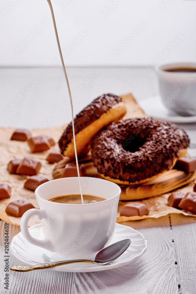 Chocolate donuts and coffee on bright wooden background Chocolate donuts and coffee on bright wooden background