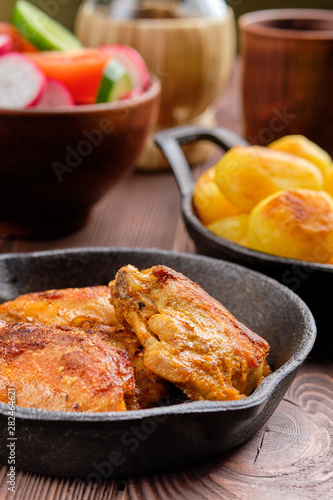 Closeup view of roasted chicken thigh with potato