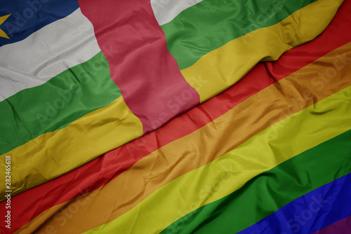 waving colorful gay rainbow flag and national flag of central african republic.