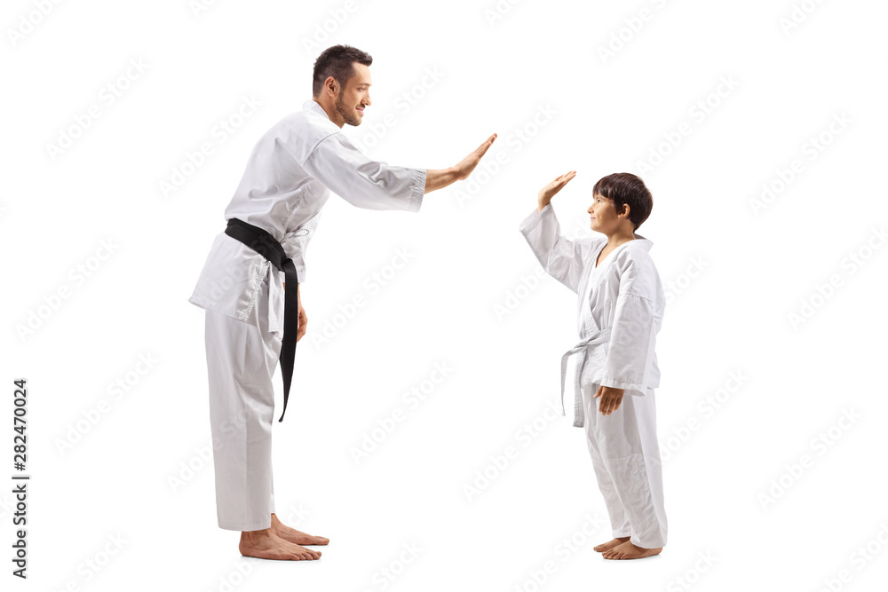 Boy and man in karate kimonos gesturing high-five