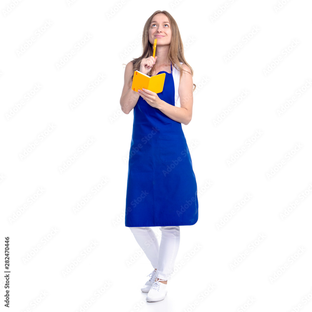 Woman in an apron in the hands of a notebook with a pen cooking recipes on a white background. Isolation Woman in an apron in the hands of a notebook with a pen cooking recipes on a white background. Isolation