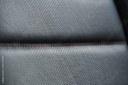 Close up of black leather detail with light and shade of a modern car interior