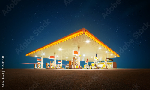 Unbranded Gas station with retail convenience store at night time .