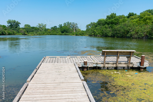 Fotografie, Obraz Small Dock with a Bench on a Water Filled Quarry in Lemont Illinois