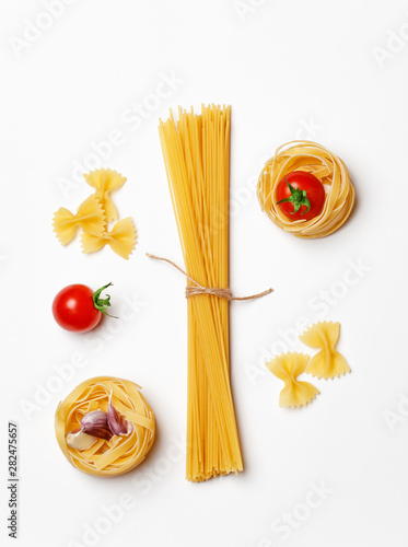 Various uncooked pasta on white background. Top view. Raw pasta with ingredients for cooking. Food concept