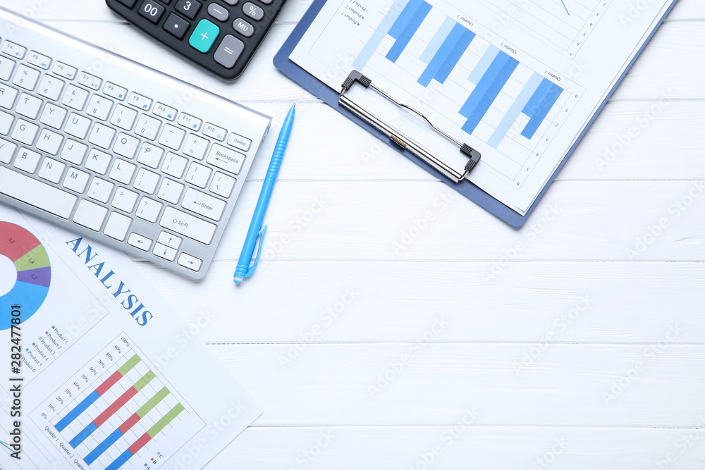 Financial papers with keyboard and calculator on wooden table Financial papers with keyboard and calculator on wooden table