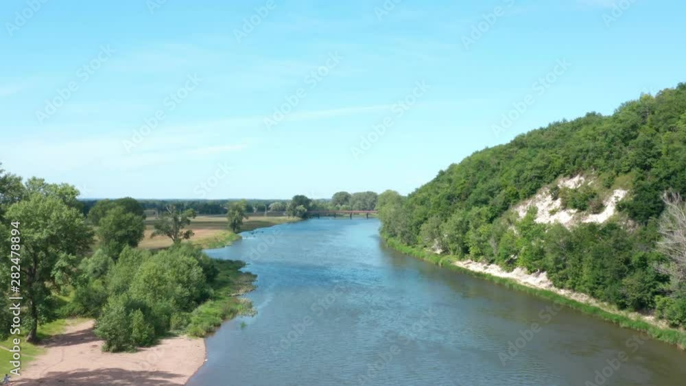 View from the copter.The camera flies along the river and filming tourists in the beach. River between mountains and forest. View from the copter.The camera flies along the river and filming tourists in the beach. River between mountains and forest.