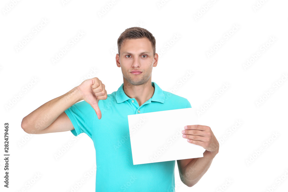 Young man with blank board showing thumb down on white background Young man with blank board showing thumb down on white background