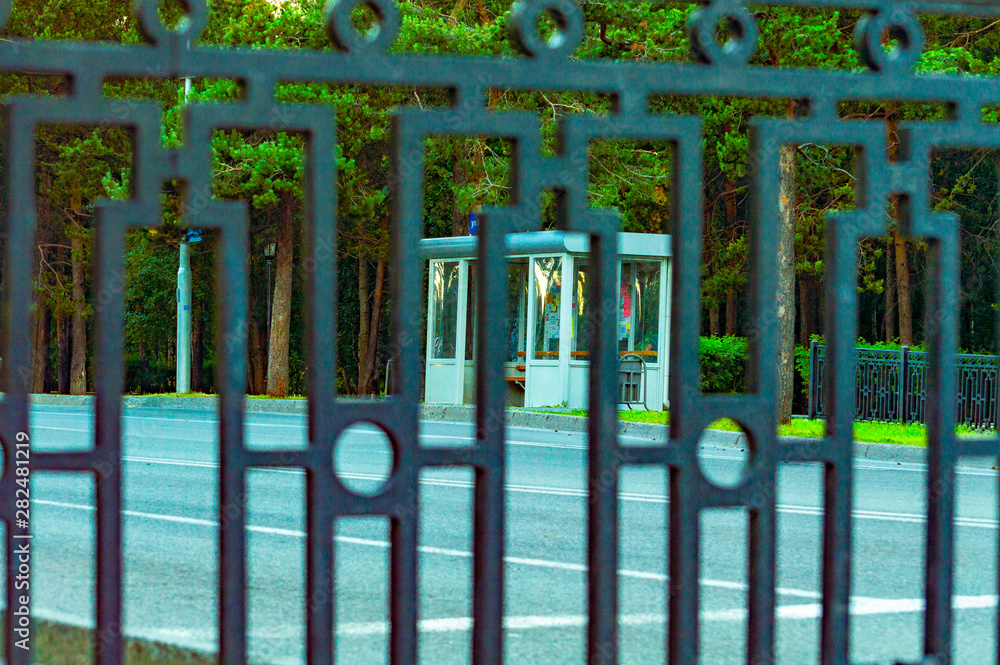 Obraz premium Stop pavilion through a metal fence. Front view. Selective focus.
