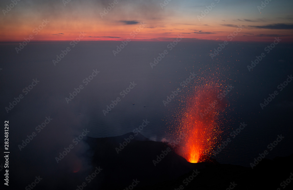 sunset from the summit of active volcano Stromboli with eruptions taking place