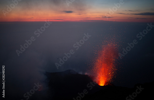 sunset from the summit of active volcano Stromboli with eruptions taking place