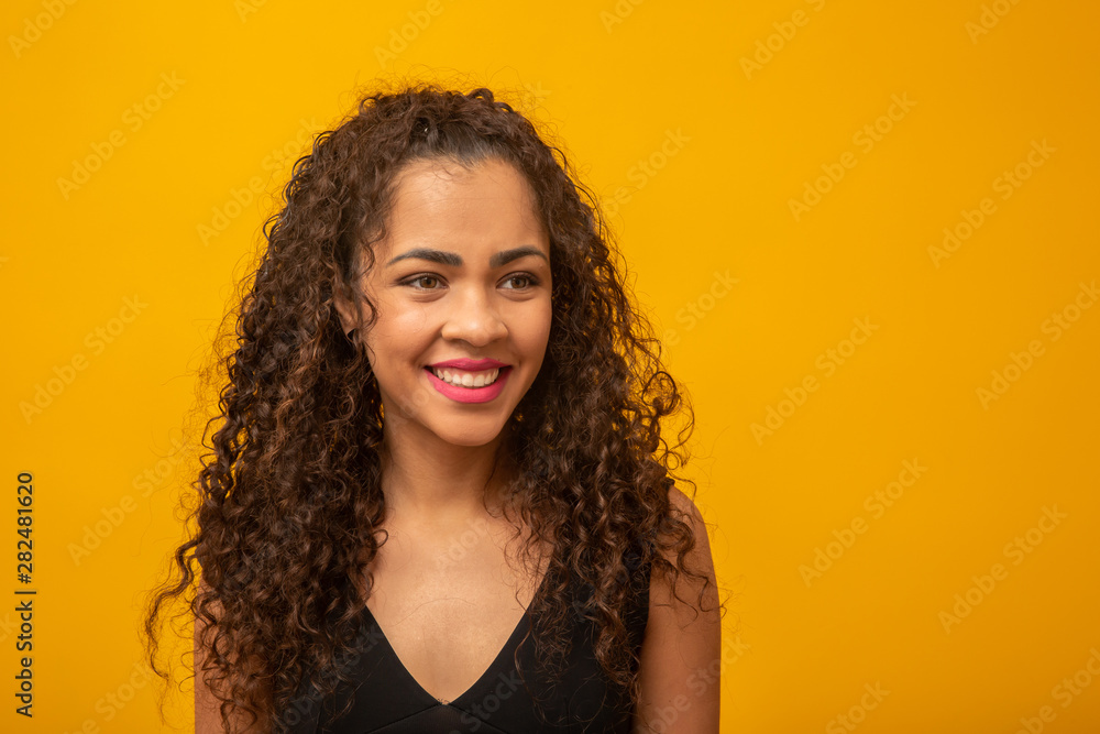 Beautiful young woman with curly hair on yellow background Beautiful young woman with curly hair on yellow background