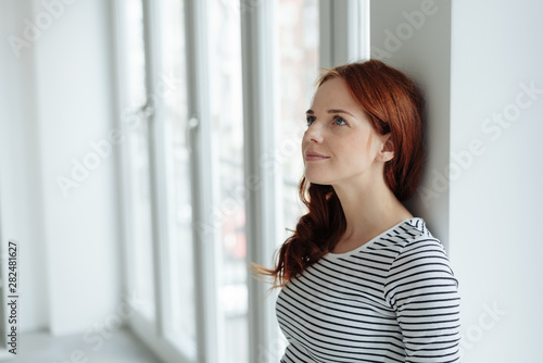 Thoughtful young woman standing daydreaming Free Download Thoughtful young woman standing daydreaming - GFXLoad