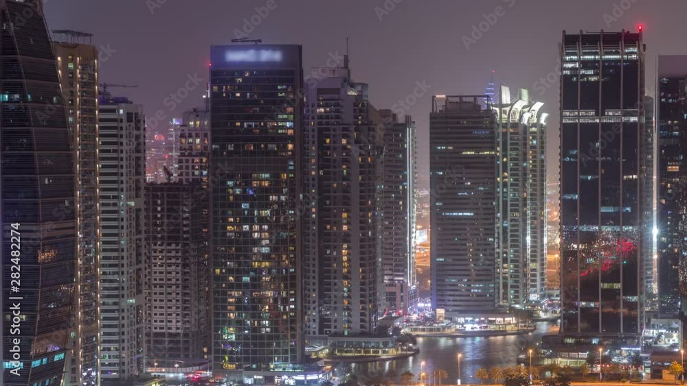 Residential and office buildings in Jumeirah lake towers district night timelapse in Dubai. Aerial panoramic view from above with modern skyscrapers Residential and office buildings in Jumeirah lake towers district night timelapse in Dubai. Aerial panoramic view from above with modern skyscrapers