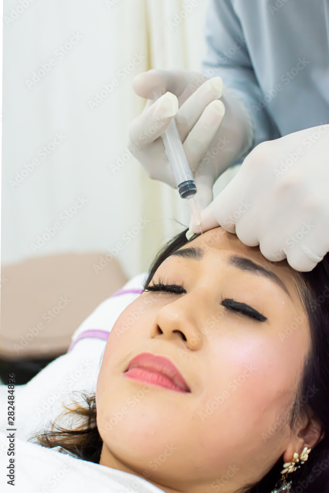 A beautiful woman is getting botox injection on face A beautiful woman is getting botox injection on face