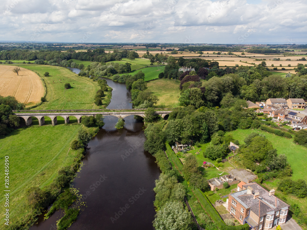 Aerial photo of the the historic Tadcaster Viaduct and River Wharfe located in the West Yorkshire British town of Tadcaster, taken on a bright sunny day