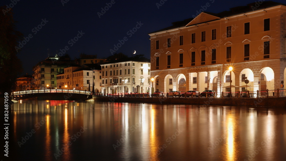 historical buildings and bridge on the river in treviso city in italy