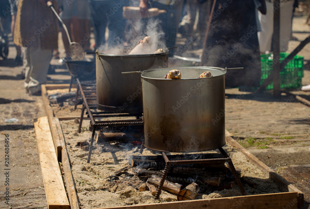 Shoulder of pork is boiling in a pan outdoors Shoulder of pork is boiling in a pan outdoors