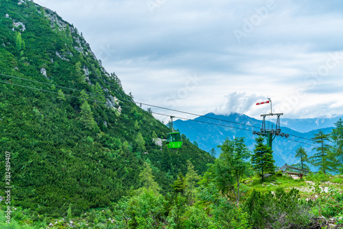 Colorful vintage gondola of Mount Katrin cable car and panoramic alpine view of peaks over Bad Ischl, Salzkammergut, Austria photo