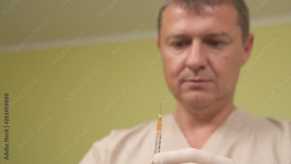 Close-up of a professional male doctor holding insulin injection syringe. Isolated, on blurred background Close-up of a professional male doctor holding insulin injection syringe. Isolated, on blurred background
