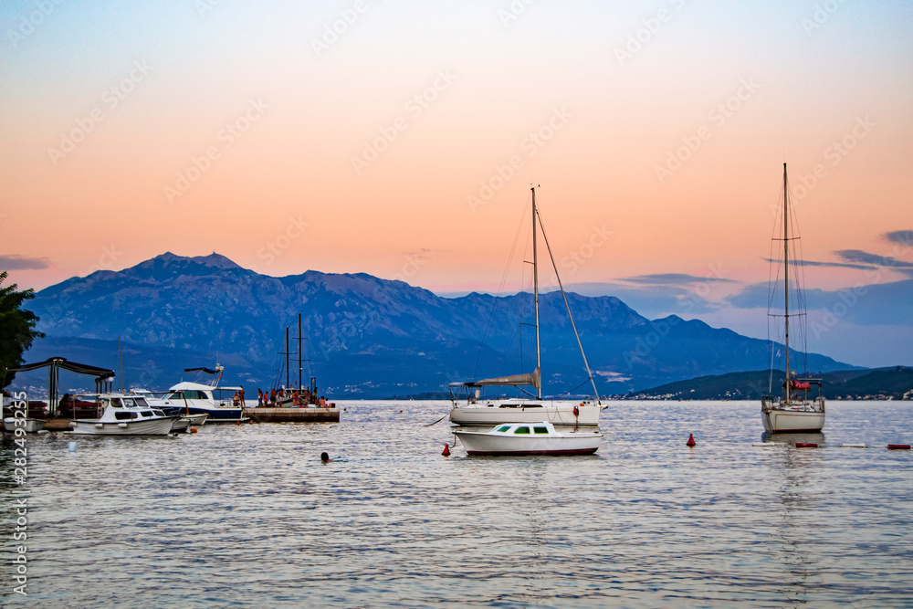 fishing and pleasure boats at anchor in a picturesque sea bay at sunset.